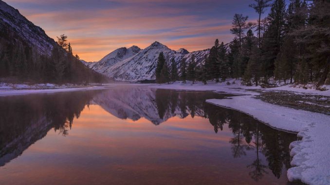 Beautiful winter landscape with mountains and a sunset sky.