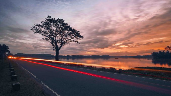 Light trails of car on road at sunset